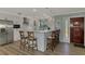 Stylish kitchen featuring white cabinetry, stainless steel appliances, a breakfast bar with seating, and modern pendant lighting at 1915 Illinois Ave, Englewood, FL 34224