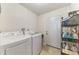 Functional laundry room with a washer, dryer, and storage shelves at 1915 Illinois Ave, Englewood, FL 34224
