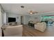Comfortable living room with a neutral color palette, plush sofa, entertainment center, and access to an outdoor patio area at 1915 Illinois Ave, Englewood, FL 34224
