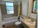 Classic bathroom with a combined shower and tub, neutral tiles, and a large vanity mirror at 194 Garden Nw Ave, Port Charlotte, FL 33952