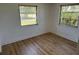 Bright bedroom with wood floors and two windows offering a view of the outdoors at 194 Garden Nw Ave, Port Charlotte, FL 33952