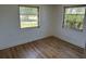 Cozy bedroom with two windows, laminate flooring, and neutral walls providing a serene atmosphere at 194 Garden Nw Ave, Port Charlotte, FL 33952