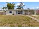 Charming single-story home with blue shutters, a covered carport, and well-maintained landscaping at 21070 Gertrude Ave, Port Charlotte, FL 33952