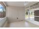 Covered patio with white tiled floors and ceiling, and access to the outdoors with a screened enclosure at 21070 Gertrude Ave, Port Charlotte, FL 33952