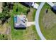 An aerial view captures the home's layout, screened pool area, and meticulously landscaped surroundings at 27 Tee View Rd, Rotonda West, FL 33947