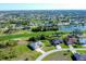 Breathtaking aerial view of homes surrounding a golf course and pond, showcasing an idyllic residential community at 27 Tee View Rd, Rotonda West, FL 33947