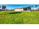View of the home's lush green backyard and screened-in patio, perfect for outdoor enjoyment and entertaining at 27 Tee View Rd, Rotonda West, FL 33947