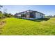Expansive green backyard with lush grass and a covered lanai area perfect for enjoying the outdoors at 27 Tee View Rd, Rotonda West, FL 33947