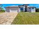 Stunning home with a brick-paved driveway, lush lawn, and three-car garage, creating a welcoming curb appeal at 27 Tee View Rd, Rotonda West, FL 33947