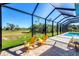 Covered lanai with beautiful view, brick pavers, and bright yellow patio furniture invites relaxation and leisure at 27 Tee View Rd, Rotonda West, FL 33947