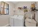Functional laundry room equipped with a washer, dryer, sink, storage shelves, and a window for natural light at 27 Tee View Rd, Rotonda West, FL 33947
