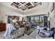 Open-concept living room featuring stylish tray ceilings, modern furniture, and seamless access to the kitchen at 27 Tee View Rd, Rotonda West, FL 33947