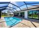 A sparkling pool sits invitingly inside the screened lanai with brick pavers and serene golf course views at 27 Tee View Rd, Rotonda West, FL 33947