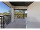 Condo balcony with white table and chairs looking out to palms and nature at 2769 N Beach Rd # 205, Englewood, FL 34223