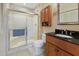 Well-lit bathroom featuring a glass enclosed shower and wood vanity with a dark countertop at 2769 N Beach Rd # 205, Englewood, FL 34223