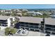 Condo building with screened balconies, two floors, and ground-level garages at 2769 N Beach Rd # 205, Englewood, FL 34223