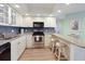 Modern kitchen features stainless appliances, sleek backsplash, breakfast bar and white cabinetry at 2769 N Beach Rd # 205, Englewood, FL 34223