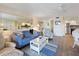 Bright living room features a blue sofa, white accents, and an open layout leading to the kitchen at 2769 N Beach Rd # 205, Englewood, FL 34223