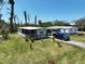 Inviting single-story home with a screened porch, blue truck, and flowering plants at 2906 Waterside Dr, Englewood, FL 34224