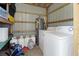 Utility room featuring a washer, dryer, water heater, and propane tanks at 2906 Waterside Dr, Englewood, FL 34224