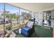 Enclosed porch features a comfortable seating area and views of lush greenery at 2906 Waterside Dr, Englewood, FL 34224
