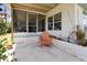 View of the covered outdoor porch with seating, a concrete floor, and a brick planter at 2906 Waterside Dr, Englewood, FL 34224