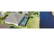 Bird's eye view features a screened pool, patio furniture, green landscaping, and canal views at 35 Medalist Rd, Rotonda West, FL 33947