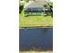 Picturesque backyard featuring a screened pool, bordered by lush landscaping and a waterfront view at 35 Medalist Rd, Rotonda West, FL 33947