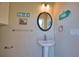 Bathroom featuring a pedestal sink, decorative mirror and beach themed decorations at 35 Medalist Rd, Rotonda West, FL 33947