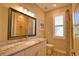 Well-lit bathroom with granite countertops and a window, creating a refreshing space at 35 Medalist Rd, Rotonda West, FL 33947