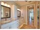 Bathroom featuring double sinks with granite counters, white cabinets, and wood-look tile flooring at 35 Medalist Rd, Rotonda West, FL 33947