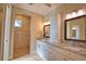 Bright bathroom featuring double sinks, granite counters, tiled shower, and a linen cabinet at 35 Medalist Rd, Rotonda West, FL 33947