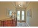 Elegant foyer with a decorative mirror, console table, and stylish double doors leading to the exterior at 35 Medalist Rd, Rotonda West, FL 33947