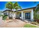 Inviting home entrance with decorative glass doors, manicured landscaping and an arched entryway at 35 Medalist Rd, Rotonda West, FL 33947