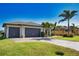 Attractive single-story home featuring a three-car garage, well-kept lawn, and lush landscaping at 35 Medalist Rd, Rotonda West, FL 33947