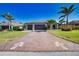 Attractive home with a two-car garage, patterned driveway and tropical landscaping at 35 Medalist Rd, Rotonda West, FL 33947