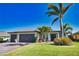 Beautiful single-story home with a three-car garage, lush green lawn, and well-manicured landscaping at 35 Medalist Rd, Rotonda West, FL 33947