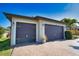 Attached two-car garage, featuring updated doors and exterior lighting fixtures at 35 Medalist Rd, Rotonda West, FL 33947