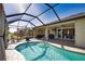 Sunlit pool enclosed within a screened lanai, complete with outdoor cooking area and dining at 35 Medalist Rd, Rotonda West, FL 33947