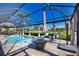A beautiful screened-in pool area with a firepit and plenty of seating at 35 Medalist Rd, Rotonda West, FL 33947