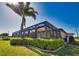 The covered and screened pool area with outdoor seating, dining area, and manicured landscape at 35 Medalist Rd, Rotonda West, FL 33947