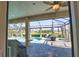 Screened-in pool area with covered patio, outdoor seating, and well-manicured landscaping at 35 Medalist Rd, Rotonda West, FL 33947