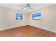 Sunlit bedroom with hardwood floors, modern ceiling fan, and dual windows at 39 Bunker Pl, Rotonda West, FL 33947