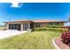 Inviting home exterior with lush lawn, decorative shrubs, and a screen garage at 39 Bunker Pl, Rotonda West, FL 33947