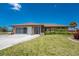 Well-kept single-story home with a manicured lawn, and a functional attached garage at 39 Bunker Pl, Rotonda West, FL 33947