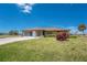 Inviting single-story home with a manicured lawn, showcasing curb appeal and a cozy entrance at 39 Bunker Pl, Rotonda West, FL 33947