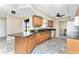 Inviting kitchen featuring an island, granite countertops, wood cabinets and ample counter space at 39 Bunker Pl, Rotonda West, FL 33947