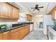 Bright kitchen boasts black granite countertops, wood cabinets, and stainless steel sink at 39 Bunker Pl, Rotonda West, FL 33947