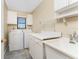 This laundry room offers a washer, dryer, sink, cabinets, and tile flooring for convenience at 39 Bunker Pl, Rotonda West, FL 33947