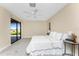 This main bedroom has neutral carpet and paint, ceiling fan, and sliding glass door at 39 Bunker Pl, Rotonda West, FL 33947